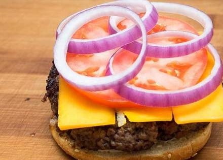 1. Этап. Бургеры из мраморной говядины: На котлету выкладываем пластинки сыра, кружочек помидора и колечки лука.