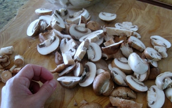 1. Этап. Говядина с овощами и грибами: Шампиньоны промываем под проточной водой, и также даем стечь воде, переложив их на бумажное полотенце. Далее, на разделочной доске при помощи ножа нарезаем наш ингредиент на четыре части и перекладываем в свободную тарелку.