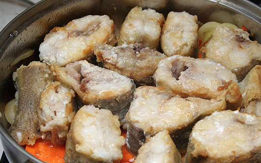 1. Этап. Минтай в томатном соусе: 6. На дно сковороды с высокими бортами выложить половину обжаренных овощей. Сверху разложить рыбу и вторую половину овощей.