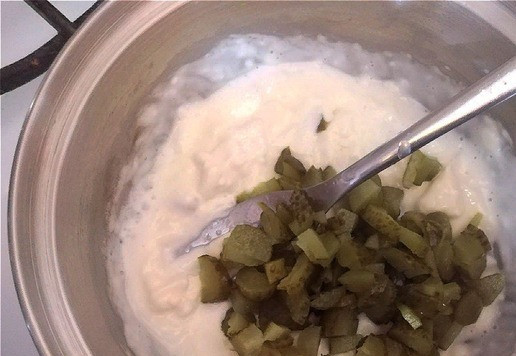 1. Этап. Бутерброд с плавленым сыром и шпротами: Вилкой сыр давим. Он разойдётся буквально за минуту. Сразу же выкладываем в него порезанные корнишоны. Перемешиваем и снимаем с огня.