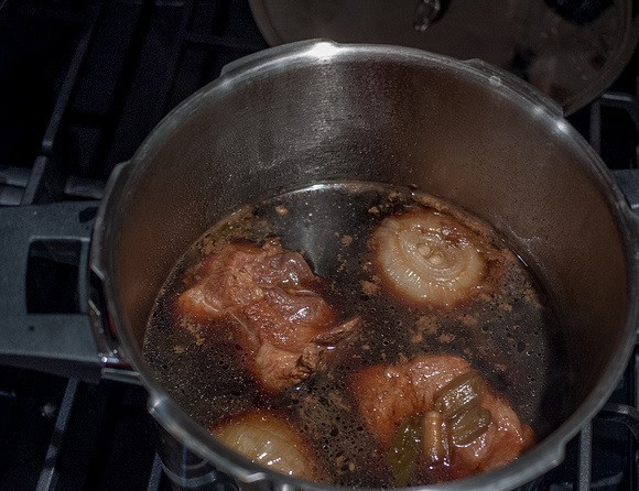 1. Этап. Буженина на сковороде: 4. Посолить и поперчить мясо. Буженина на сковороде в домашних условиях может быть дополнена любыми специями и приправами для мяса по вкусу. Затем аккуратно переложить свинину со сковороды в кастрюлю вместе с овощами и добавить лук. Довести до кипения и убрать огонь до минимума.