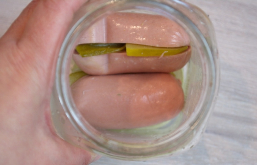 1. Этап. Утопенцы (шпикачка): Плотно уложите в банку наполненные шпикачки, чередуя их с кольцами лука.