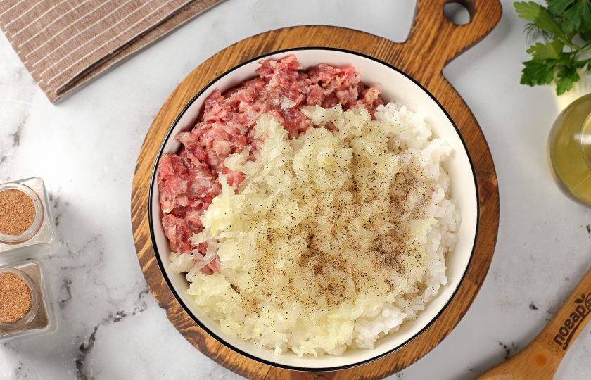 1. Этап. Голубцы из пекинской капусты: Фарш переложите в глубокую миску. Добавьте отваренный рис, тёртую на крупной тёрке луковицу, соль и перец по вкусу.