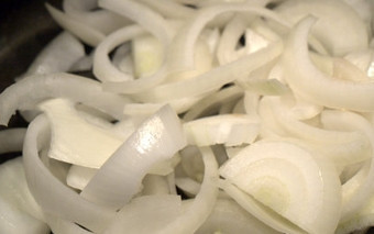 1. Этап. Говядина с овощами и грибами: При помощи ножа очищаем лук от шелухи, промываем под проточной водой. Затем - на разделочной доске с помощью ножа нарезаем наш ингредиент на средние колечки и перекладываем их в свободную тарелку.