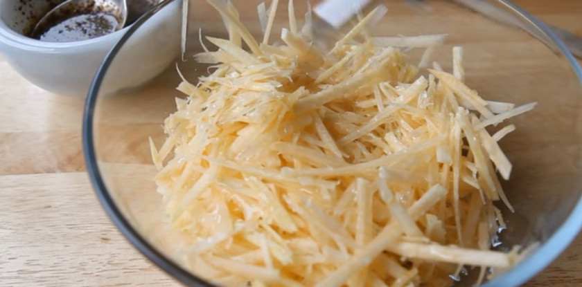 1. Этап. Салат из брюквы: 6. Выложите брюкву в миску, заправьте ее подсолнечным маслом.