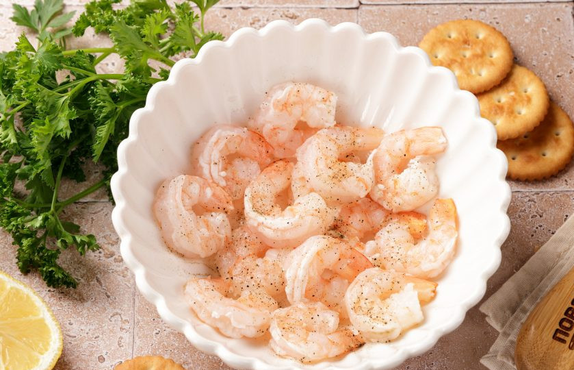 1. Этап. Канапе с креветкой на крекере: Креветки слегка посолите, поперчите и сбрызните лимонным соком.