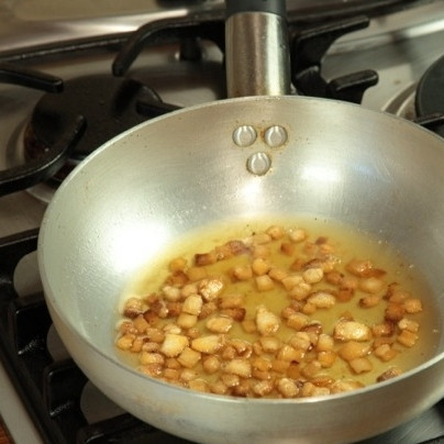 1. Этап. Кугелис: Картофель очистить и натереть на средней терке (можно измельчить кухонным комбайном). Сало нарежьте на небольшие кубики и обжарьте в масле, чтобы оно подрумянилось (но не нужно сушить сало до шкварок, оно должно остаться жирным).