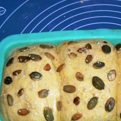 1. Этап. Хлеб с тыквенными семечками: Тесто еще немного поднимется. Теперь его необходимо смазать взбитым желтком и и посыпать тыквенными семечками.