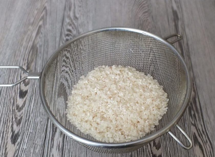 1. Этап. Плов в рукаве: Рис промойте в нескольких водах. Переложите на дуршлаг и дайте стечь воде.