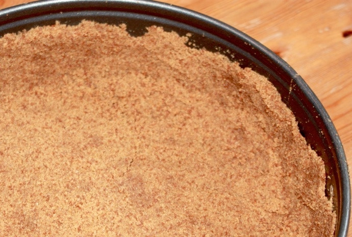 1. Этап. Вкуснейший чизкейк: 2. Измельчите крекеры в крошку, смешайте с 60 граммами растопленного сливочного масла. Выложите полученную смесь в форму для выпекания, распределите, сформировав бока.