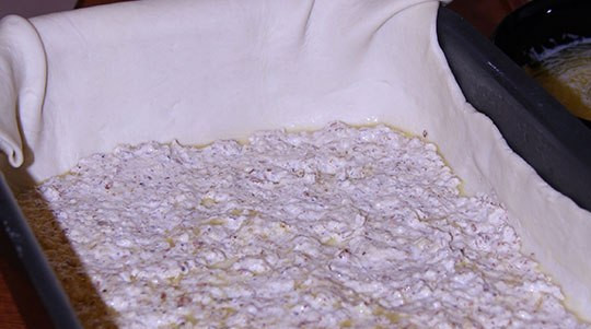 1. Этап. Пахлава из слоеного теста: Затем мы выкладываем слой из орехово-белково-сахарной массы, распределяем ее равномерно по всему периметру.
