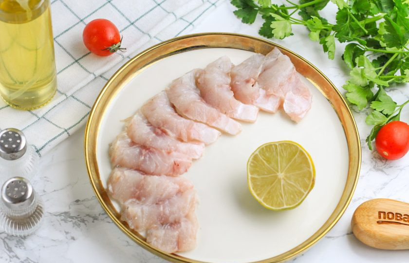 1. Этап. Севиче из сибаса: Тушку сибаса отфилетируйте и снимите с филе кожу. Промойте, обсушите бумажными салфетками и нарежьте порционными ломтиками. В приготовлении севиче нарезка не принципиальна — вы можете нарезать филе кубиками, ломтиками вместе с овощами.