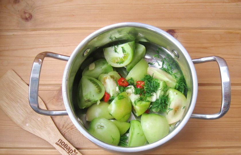 1. Этап. Зеленые помидоры дольками на зиму: В кастрюлю выложите нарезанные помидоры, красный перец, чеснок и укроп.