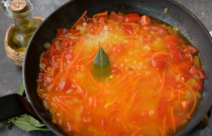 1. Этап. Плов с рапанами: Влейте теплую воду из чайника, она должна быть выше содержимого сковороды на 1 сантиметр. Добавьте лавровый лист, соль и перец по вкусу, можно положить любимые приправы для плова или зиру. После закипания воды, накройте сковороду крышкой, сделайте самый тихий огонь, и готовьте рис 10 минут.