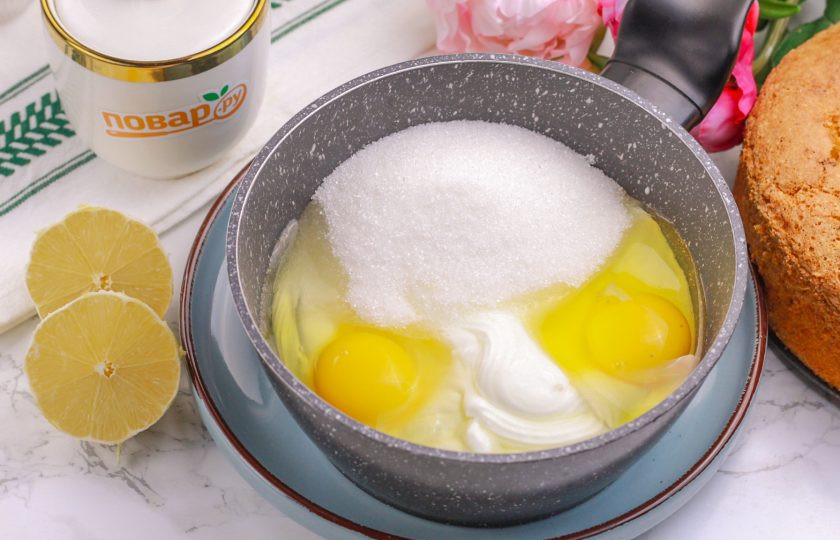 1. Этап. Лимонный бисквит: Выложите жирную сметану в казан или ковш с антипригарным дном, вбейте туда же куриные яйца, всыпьте соль и влейте лимонный сок. Сок лимона добавляйте обязательно, так как он выделит сливочный вкус крема.