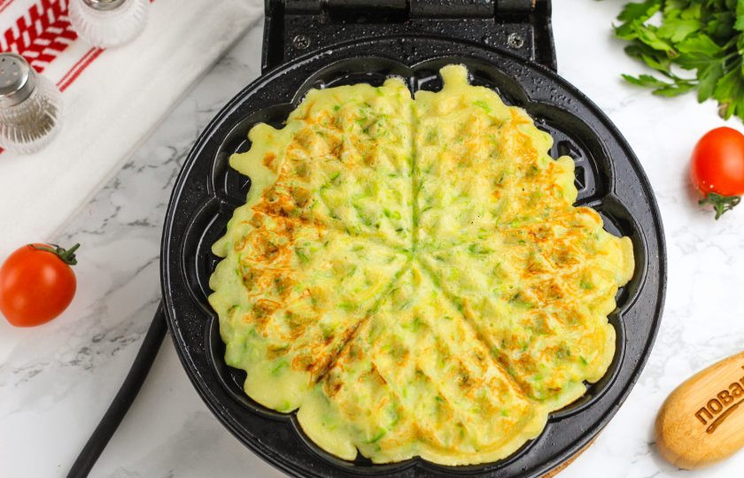 1. Этап. Вафли кабачковые в вафельнице: Прогрейте вафельницу и сбрызните панели растительным маслом. Выложите 2 ст.л. приготовленного теста и закройте вафельницу. Испеките вафли примерно 3-4 минуты до румяности. Верхнюю панель вафельницы можно немного прижать для получения румяности на выпечке.