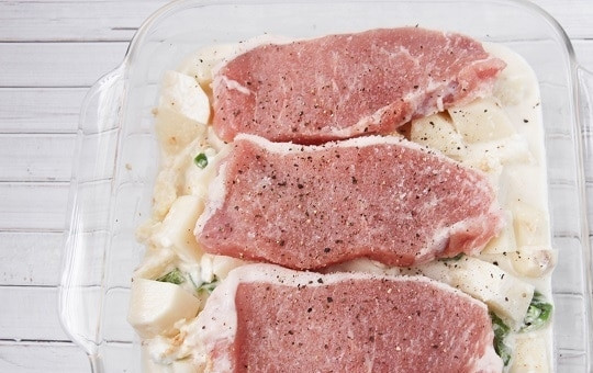 1. Этап. Картошка со свининой в духовке: Кусочки свинины тоже солим и перчим, выкладываем на картофель.