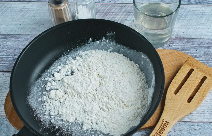 1. Этап. Запеченная картошка с сыром чеддер: На сухой сковороде нагрейте муку до появления легкого орехового запаха. Влейте 2 ст. л. куриного бульона, перемешайте до однородности.