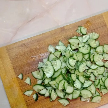 1. Этап. Салат из молодой капусты с уксусом: Огурец нарезать четвертинками.