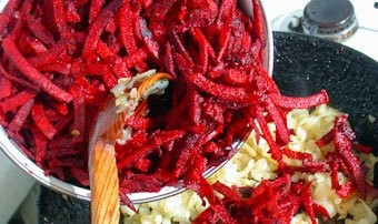 1. Этап. Свекла, тушенная с луком: Свеклу хорошенько вымойте. Очистите овощи от кожуры, нарежьте соломкой. Можно натереть свеклу на крупной терке, тогда время ее приготовления уменьшится приблизительно вдвое. Добавьте свеклу в сковородку.