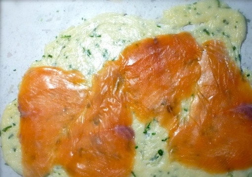 1. Этап. Сырные рулетики с семгой: 5. Расстелите пищевую пленку и выложите на него равномерно сырную массу. Накройте сверху вторым куском пищевой пленки. Раскатайте до формы прямоугольника. Снимите верхнюю пленку. Выложите кусочки семги на сырный прямоугольник так, чтобы не было нахлестов.