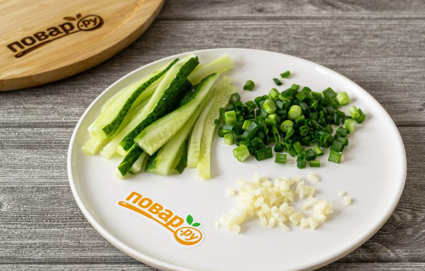 1. Этап. Лапша Нэнмён: Огурец нарежьте брусочками, подсолите. Чеснок и зеленый лук мелко порубите.