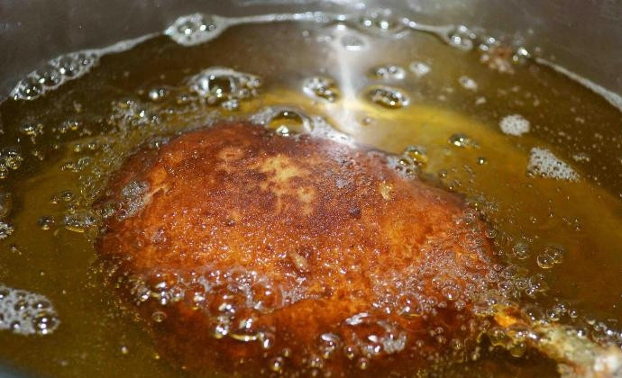 1. Этап. Котлеты по-киевски классические: Сделайте фритюр с маслом. Когда он будет разогретым, то убавьте огонь до минимума. Обжарьте изделия во фритюре.