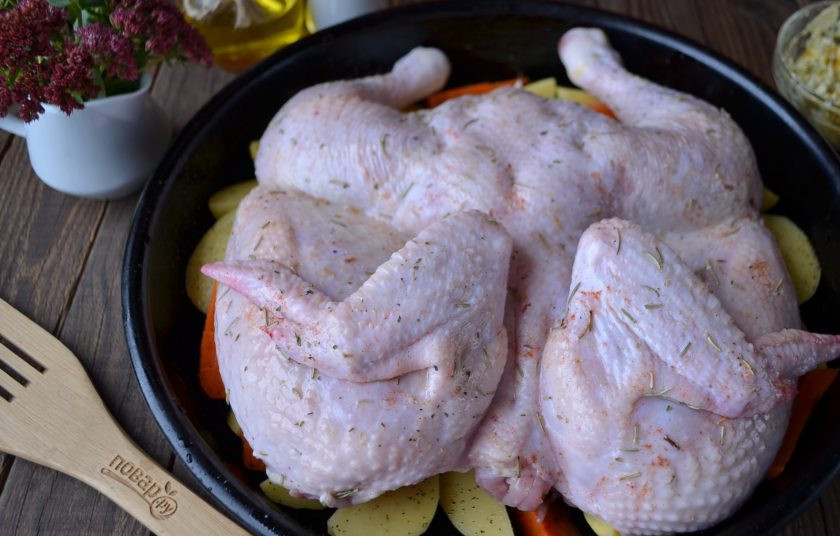 1. Этап. Жареный цыпленок целиком: Сверху положите цыпленка на овощи.