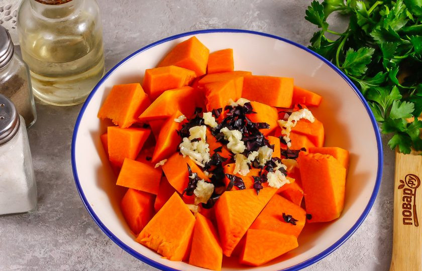 1. Этап. Тыква запеченная с базиликом: Очистите зубчики чеснока и промойте вместе с базиликом. Измельчите зелень, а чеснок спрессуйте и добавьте все к тыквенной нарезке.