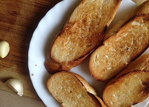 1. Этап. Брускетта: Хрустящие обжаренные кусочки хлеба натираем чесноком.