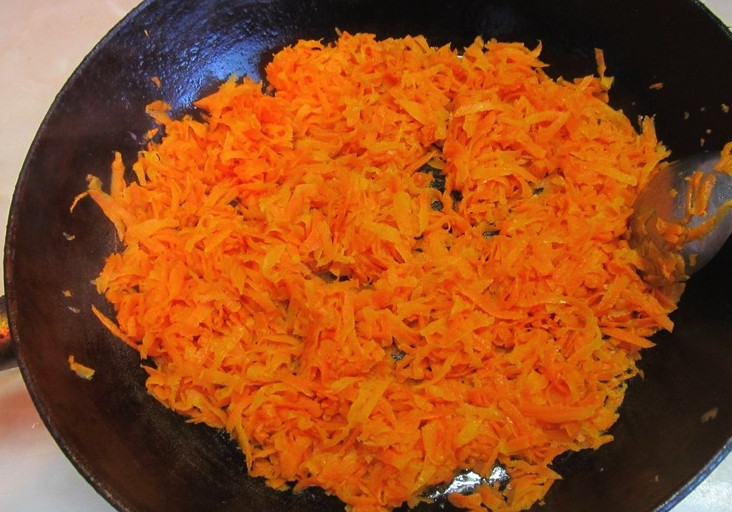 1. Этап. Салат с говяжьим сердцем: Яблоко и морковь очистите и натрите на крупной тёрке. Также натрите сыр. Очистите яйца, натрите и их, отложив два натёртых желтка отдельно. В сковороде разогрейте немного растительного масла, обжарьте на нём морковь до золотистого цвета. Нужно, чтобы она стала мягкой.