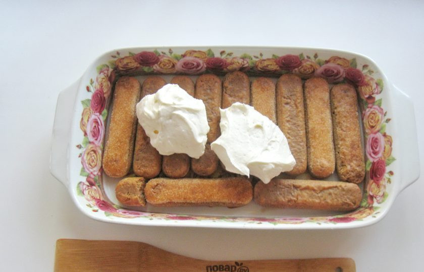 1. Этап. Торт Тирамису: Половину крема выложите на слой печенья.