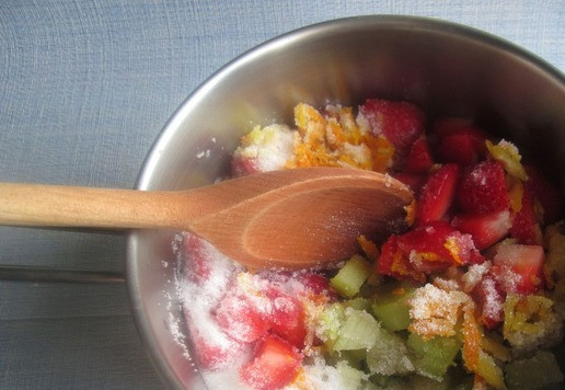 1. Этап. Джем из ревеня, клубники и изюма: Добавить сахар, перемешать и поставить на огонь. Варить на медленном огне, помешивая, до растворения сахара.