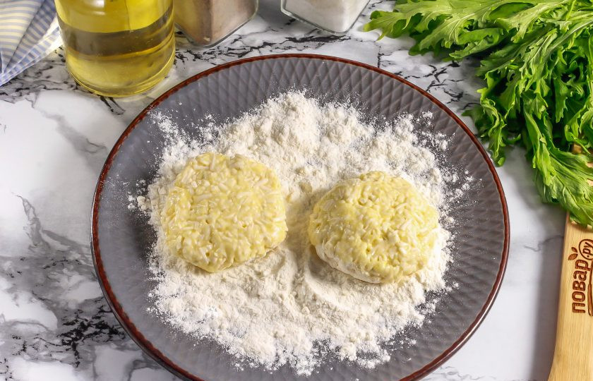 1. Этап. Сырники из плавленых сырков: Смочите ладони в воде и сформируйте из сырного теста небольшие котлетки. Обпанируйте их в оставшейся муке со всех сторон.