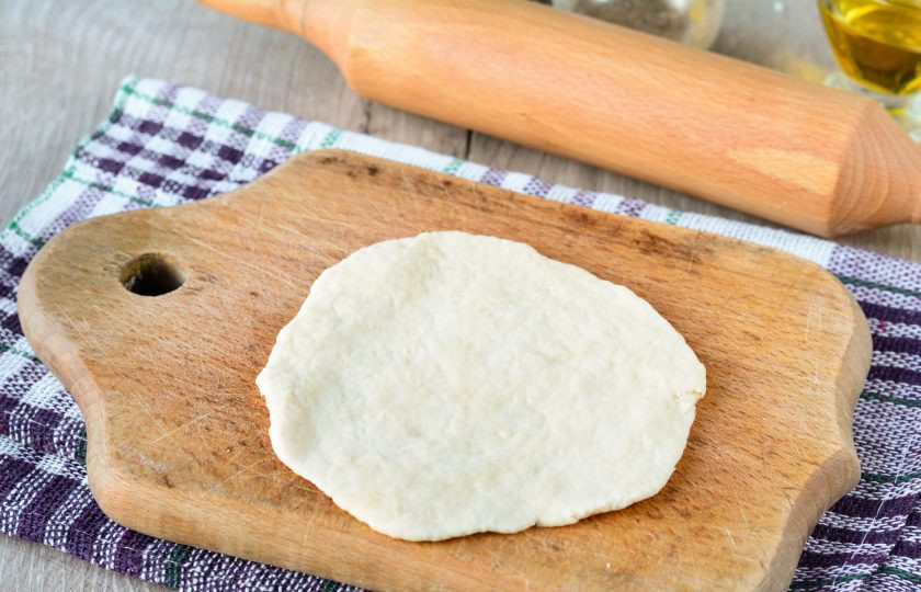 1. Этап. Жареные пирожки на заварном тесте: Тесто разделите на 6-7 шариков, каждый раскатайте тонкой лепешкой при помощи скалки.