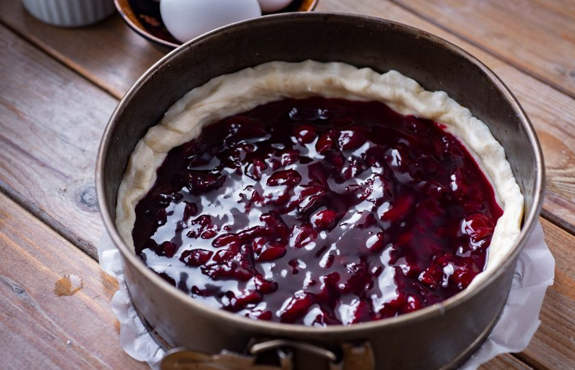 1. Этап. Пирог с замороженной вишней и безе: Тесто достаньте из холодильника, немного раскатайте скалкой, выложите в форму, застеленную пергаментом для выпекания, формируя бортики высотой примерно в 4 см. Вишневую массу выложите в основу из теста, разравнивая ложкой, отправьте выпекаться в уже разогретую до 180 градусов на 35 минут.