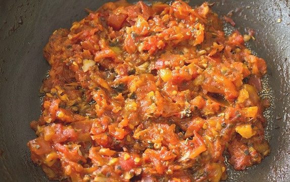 1. Этап. Пицца своими руками: Чеснок измельчите и обжарьте на масле минутку, затем добавьте помидоры, соль, травы, перец. Дождитесь, пока жидкость выпарится.