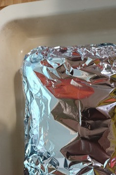 1. Этап. Грудинка запеченная в духовке: Оборачиваем грудинку фольгой в несколько слоев. Выкладываем её на противень и отправляем в разогретую до 200 градусов духовку на 1,5 часа.