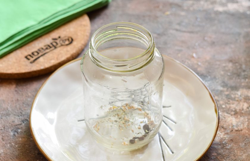 1. Этап. Маринованный крыжовник на зиму: Подготовьте баночку для заготовки, вымойте и простерилизуйте удобным способом вместе с крышкой. На дно банки выложите ложку специй для засолки — кориандр, горчицу в зернах, сушеный чеснок, перец горошком.