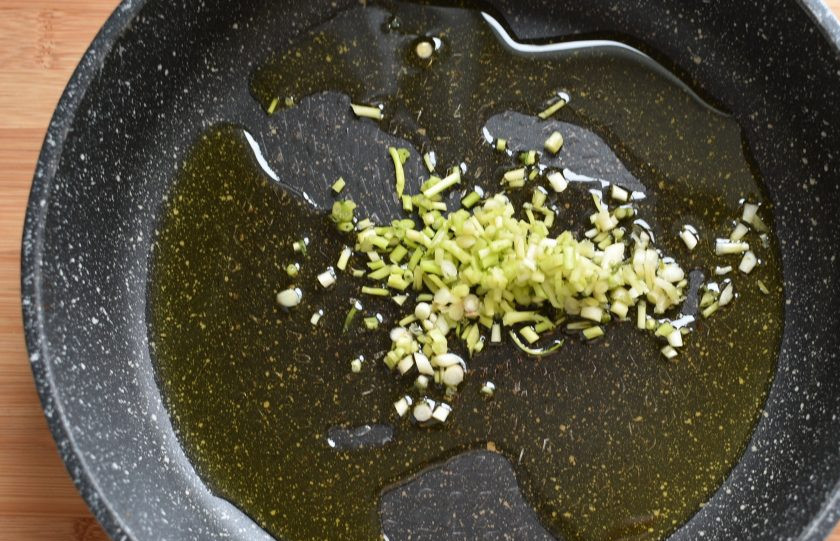 1. Этап. Паста с колбасками, маслинами и пряными травами: Предлагаю готовить параллельно на двух конфорках. Поставьте пасту вариться в большой кастрюле соответственно инструкции на упаковке. Варите до состояния аль-денте. Чеснок раздавите плашмя ножом, так он быстрее очиститься. Нарубите его достаточно мелко и слегка обжарьте на большой сковороде с оливковым маслом. У меня молодой зеленый чеснок, с ним тоже получается вкусно.