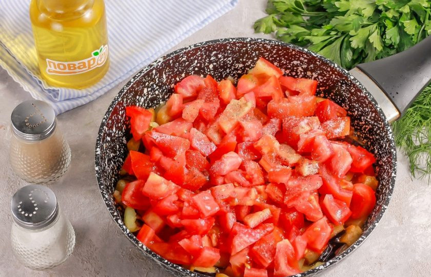 1. Этап. Шакшука с баклажанами и лимонной цедрой: В это время промойте помидоры и вырежьте из них зеленые сердцевинки. Нарежьте сердними или мелкими кубиками и добавьте в емкость. Всыпьте соль и молотый черный перец. Потушите все примерно 5 минут.