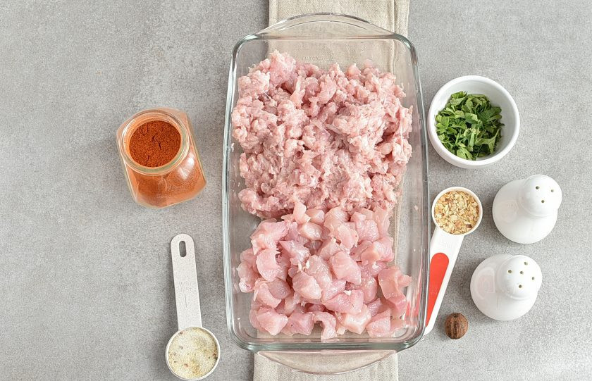 1. Этап. Домашняя ветчина из курицы: Мякоть курицы, за исключением филе грудки, пропустите через мясорубку с крупной решеткой дважды. Филе грудки нарежьте вручную кубиками средних размеров. Таким образом, на срезе получится красивый «мраморный» рисунок.