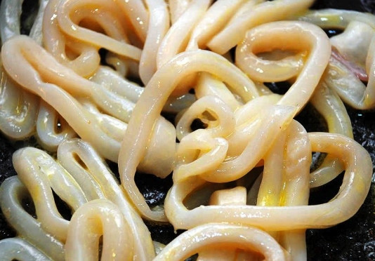 1. Этап. Вкусный салат из кальмара: Для начала нарежьте кальмар тонкими кольцами. Их толщина должна составлять не более 5 миллиметров. Кольца обжарьте на разогретом масле на сильном огне 2-3 минуты, постоянно переворачивая их.