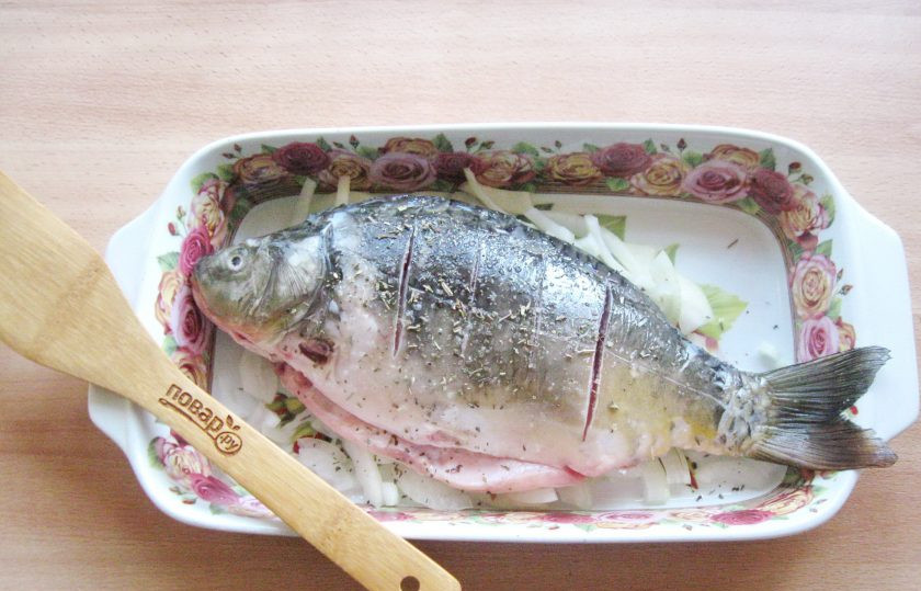 1. Этап. Карп в духовке на луковой подушке: Посыпьте приправой для рыбы. Отправьте карпа в духовку, разогретую до 180 градусов.