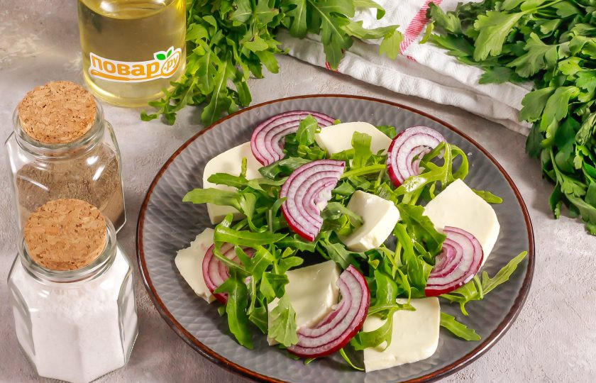 1. Этап. Салат с адыгейским сыром и помидорами: Разрежьте красную луковицу пополам и нарежьте ее половину тонкими полукольцами. Выложите на тарелку.