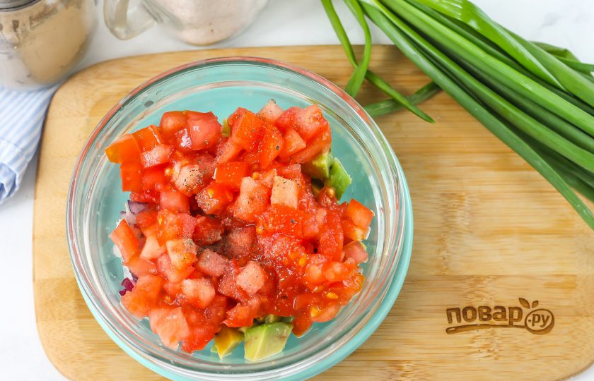 1. Этап. Брускетта с гуакамоле и креветками: Помидор промойте в воде, вырежьте сердцевинку и нарежьте плод мелким кубиком. Добавьте в емкость к остальным нарезкам, посолите и поперчите. Влейте лимонный сок и растительное масло, тщательно перемешайте.