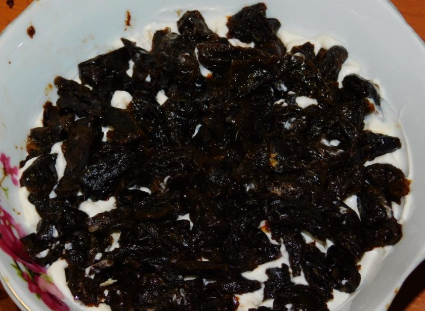 1. Этап. Слоеный салат с черносливом: Чернослив залейте кипятком на 3-5 минут. Обсушите, нарежьте и выложите следующим слоем.