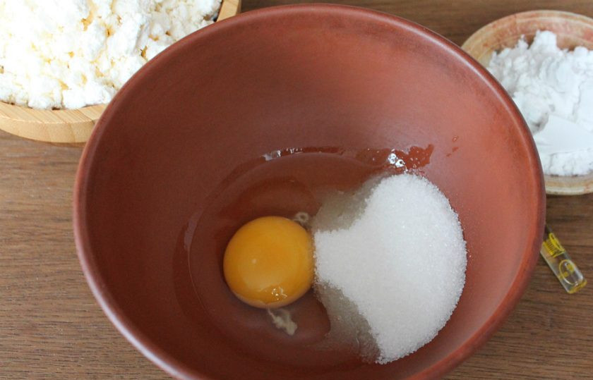 1. Этап. Сырники с крахмалом: В миску насыпаем сахар, соль и добавляем яйцо. Все взбиваем венчиком.