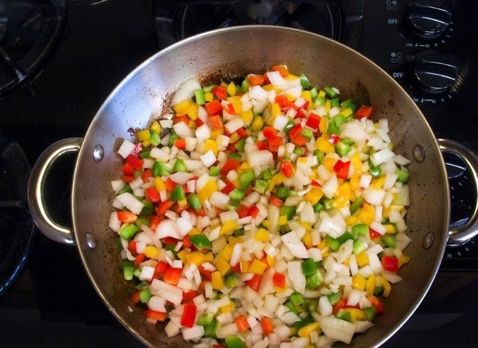 1. Этап. Говядина по-африкански: 2. Затем мясо уберите, а на его место выложите мелко нашинкованный белый репчатый лук и перец. Тушите овощи 5 минут, иногда помешивая.