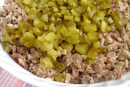 1. Этап. Cалат Оливье с мясом: Следом в миску отправляются соленые огурцы, порезанные кубиками.